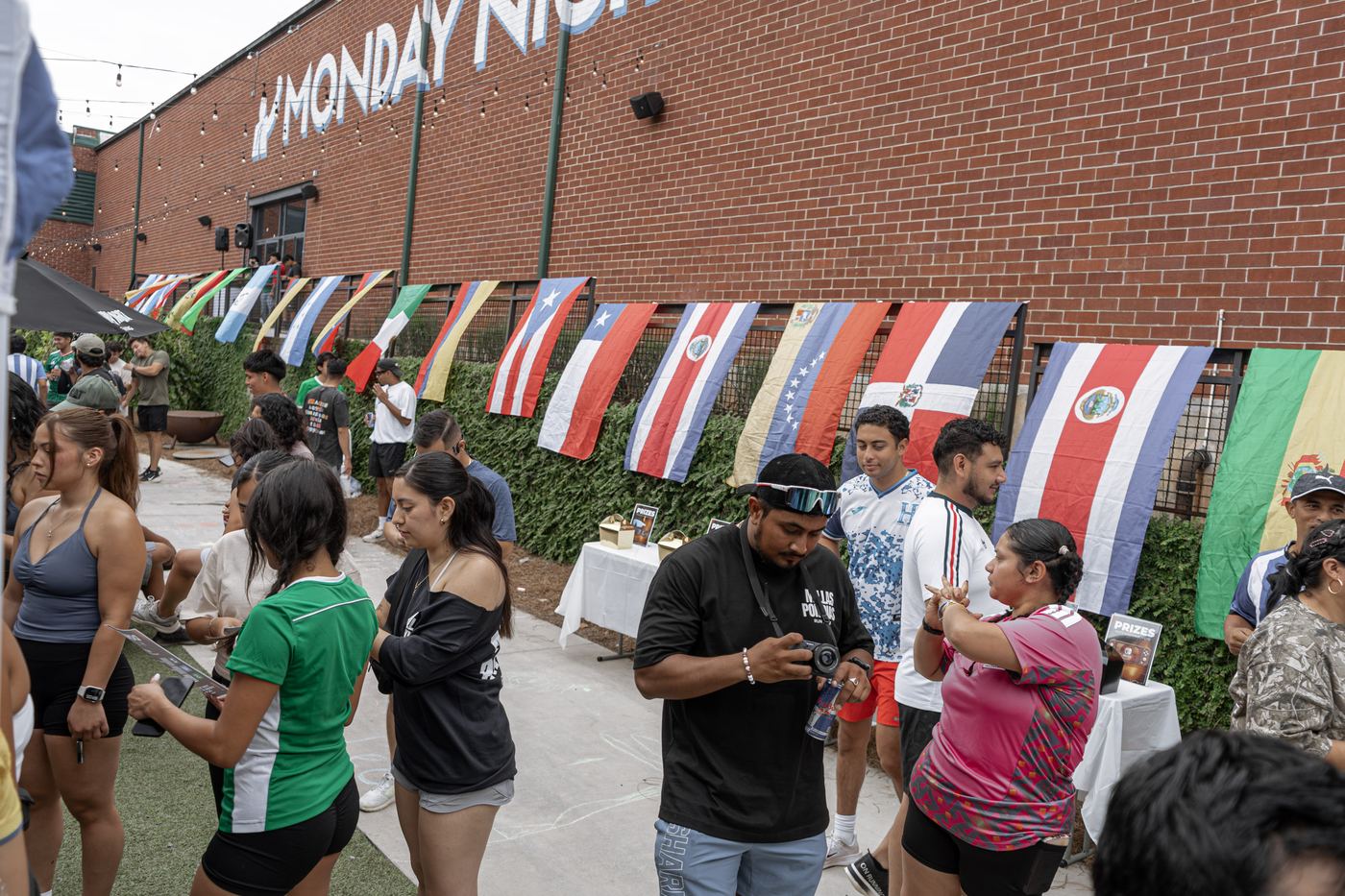 Flags from across Latin America hung in a row along the courtyard fence, beside the prize tables.